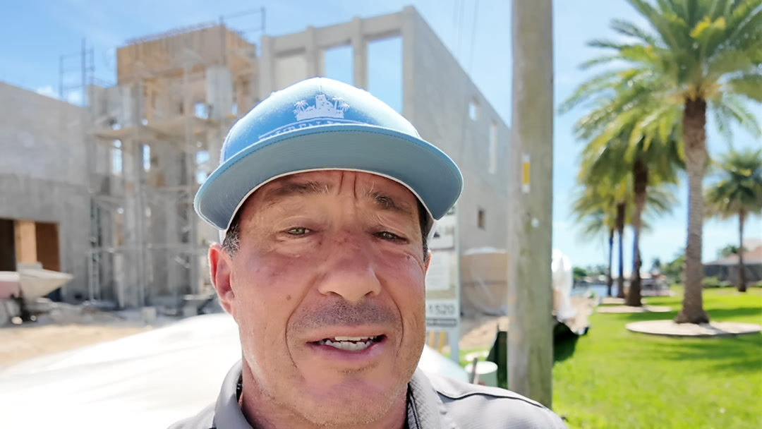 Fred Price of Lauren Homes in front of a two-story custom home under construction in Cape Coral, Florida