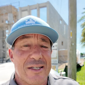 Fred Price of Lauren Homes in front of a two-story custom home under construction in Cape Coral, Florida