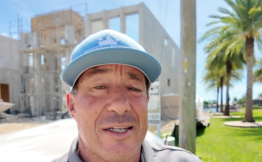 Fred Price of Lauren Homes in front of a two-story custom home under construction in Cape Coral, Florida